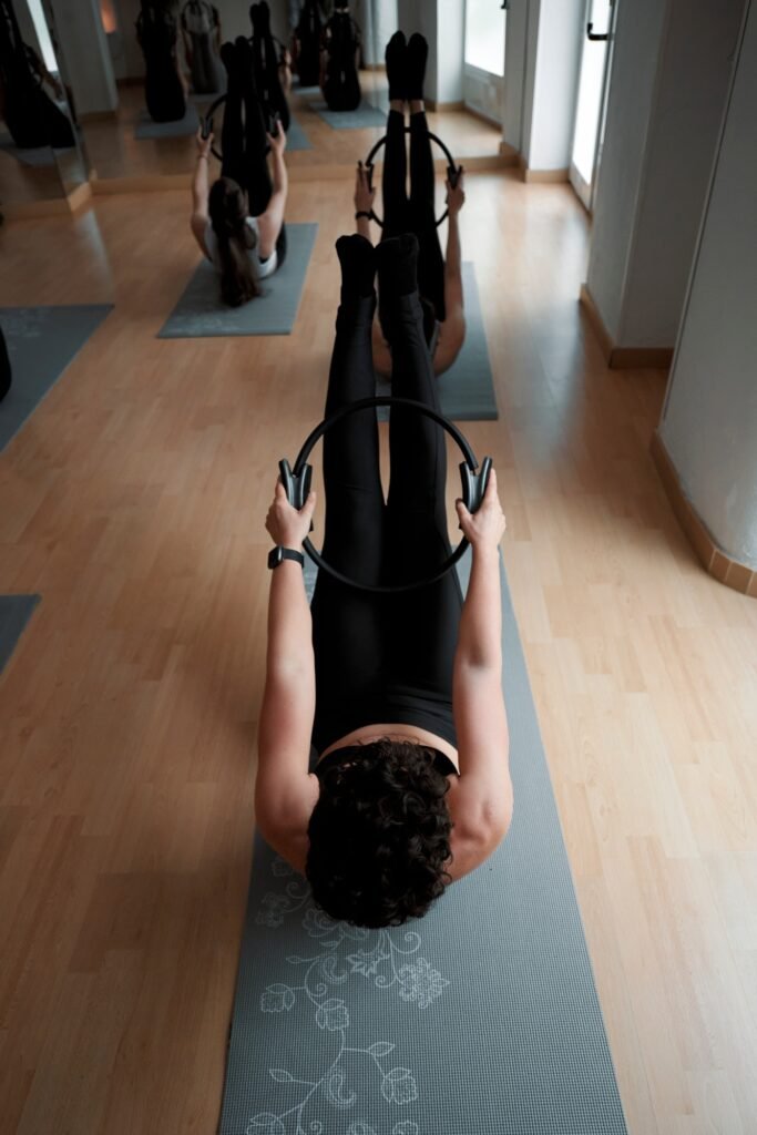 Young women exercising with the Pilates ring in class
